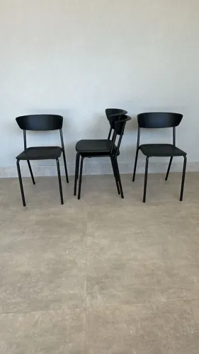 4 cadeiras pretas com encosto plástico e pés de metal