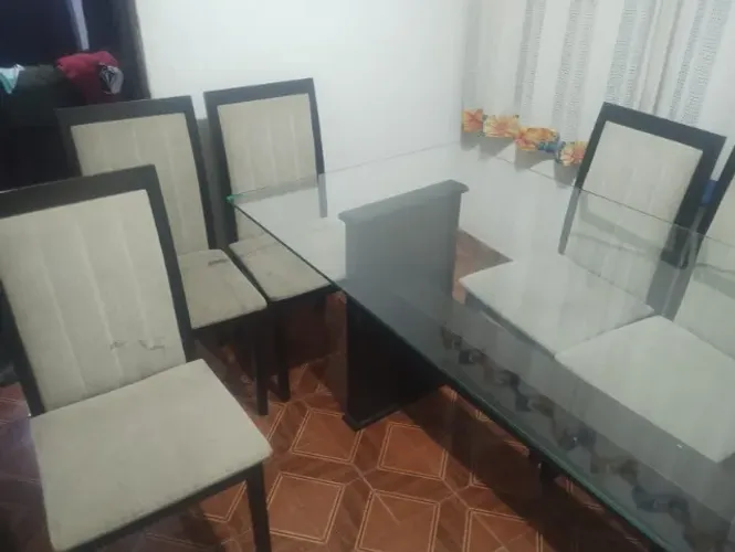 Mesa de vidro e como cadeiras.