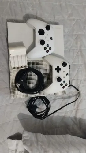 XBox One 512GB acompanha 2 controles, carregador de baterias, 4 baterias E cabos.