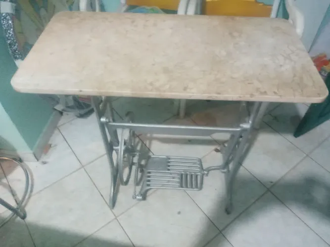 Pe maquina de custura antigo com pedra de granito