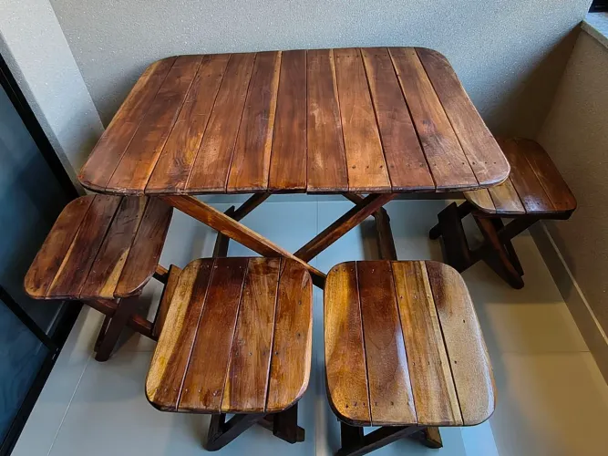 Mesa e 4 cadeiras de madeira dobráveis.