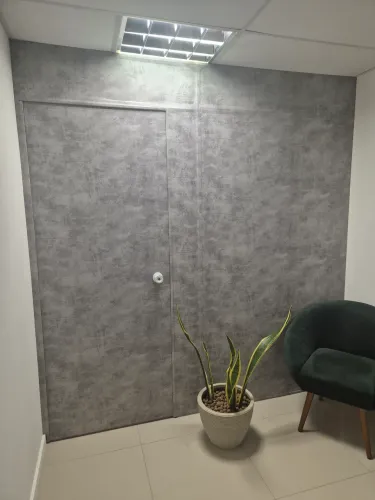 Vendo divisória em Eucatex, revestida com adesivo padrão cimento queimado.