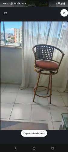 Baqueta alta giratória com estrutura traçada, encosto quadriculado, braços de apoio.