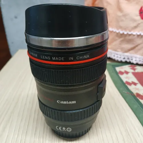 Vendo esse copo em forma de lente de câmera Canon 