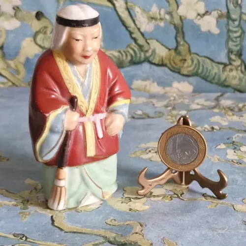 Estatueta Oriental de uma sábia que varre a sorte para dentro de casa.Mede 10 cm