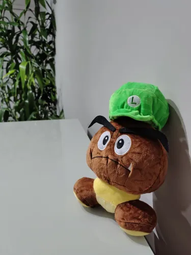 Pelúcia do Goomba do Mario Bros com chapéu do Luigi.