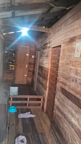 Casa de dois andares, encima de madeira com 2 quartos, áreas atrás e na frente.