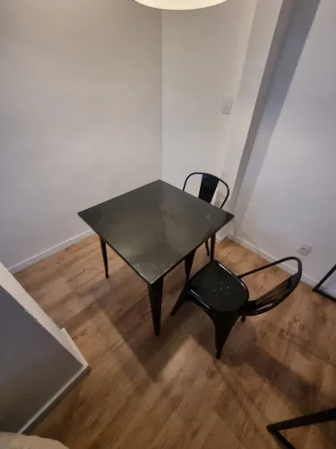 Mesa e cadeiras de ferro, na cor preta.