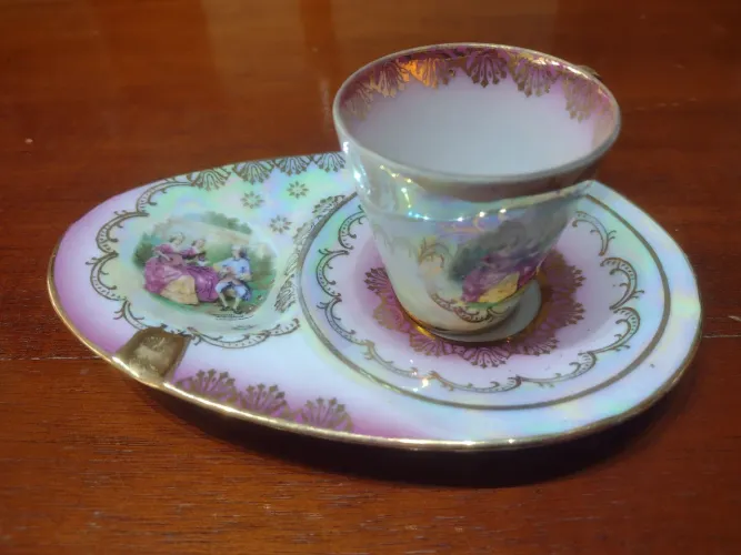 Vendo antiga xícara de porcelana cena galante com pires estendido