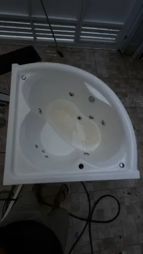 Banheira hidromassagem de canto com aquecedor e controle digital.