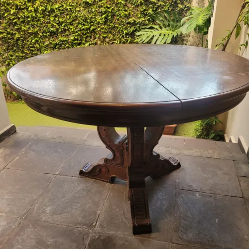 Mesa redonda com base oda trabalhada. Necessita restauro do tampo.