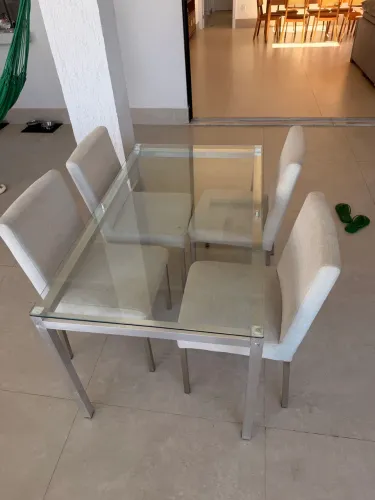 Mesa com tampo de madeira e pés de inox com 4 cadeiras.