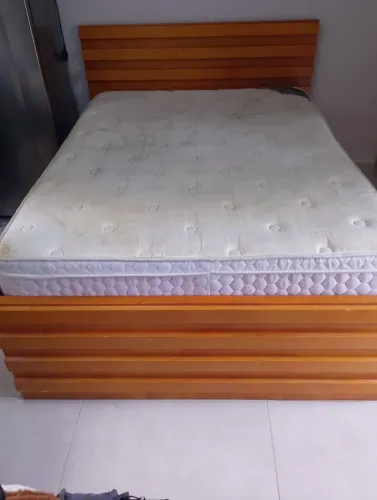 Cama de madeira com 4 gavetas e um colchão.