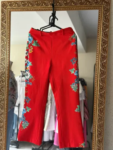 Calça vermelha Zara com estampa floral verde lateral