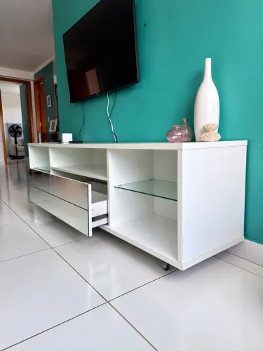 Rack branco para TV com gavetas, vidro e rodízios
