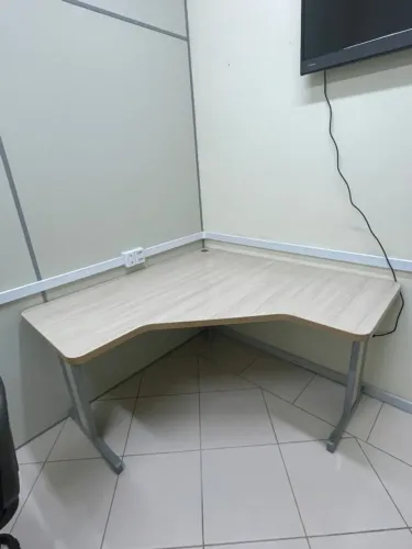 Mesa delta em L da linha Uno, feita de MDP de 15 mm com pés metálicos.