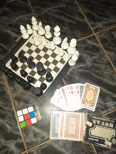 Dois baralhos um jogo de damas e bolinhas e um cubo mágico 