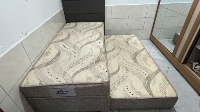 Cama de solteiro com auxiliar mais cabeceira.