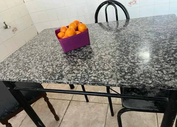Mesa de mármore com 2 cadeiras mais 2 cadeiras, que precisam de reparo