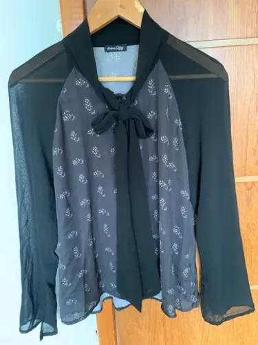 Blusa de manga com detalhe de gravata de laço.