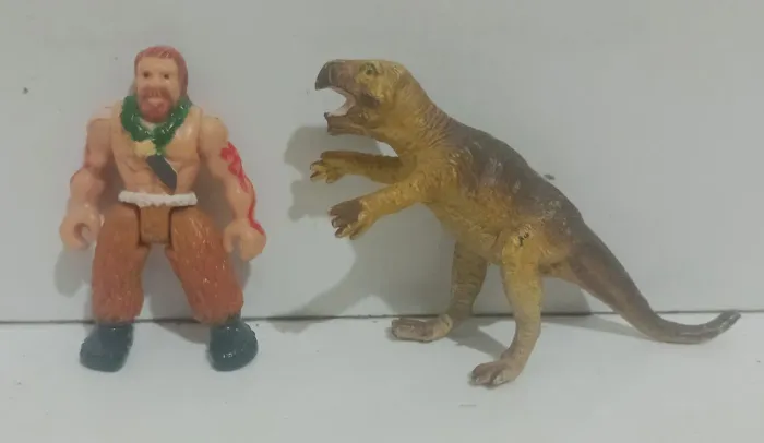 Bonecos antigos de Dinossauro e Homem das Cavernas