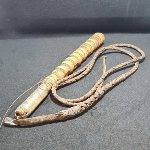 Chicote de couro cru, com cabo de madeira conhecido como caipira.