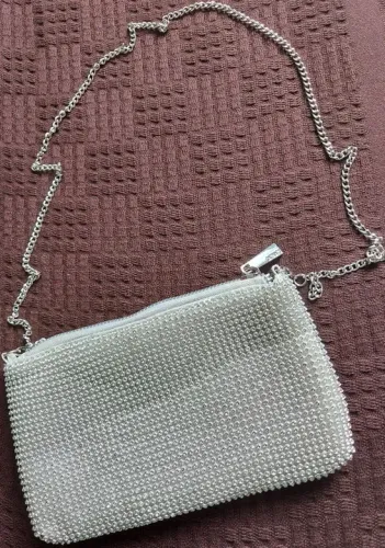 bolsa transversal com alça corrente fechamento zíper e detalhes strass