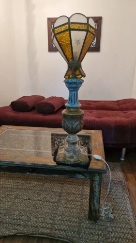 Abajur de mesa com base de madeira torneada e cúpula de vidro colorido estilo Tiffany. 