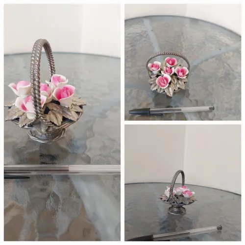 Cesta de metal com rosas em porcelana.<br>Medidas: 9x9/altura 20cm<br>Valor: 40,00