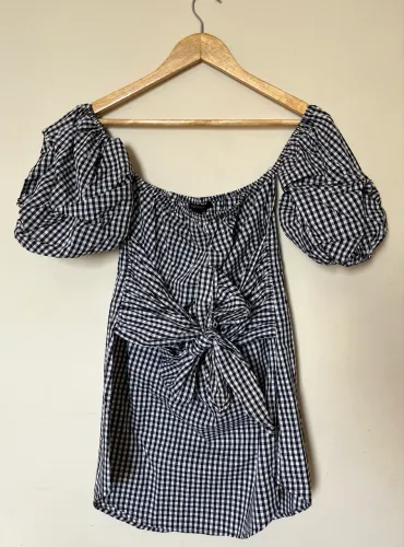 Vestido ombro a ombro, xadrez preto e branco, mangas bufantes, detalhe com amarração.