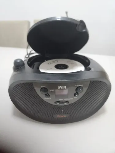 jWIN JX-CD427, um boombox portátil preto com reprodutor de CD e rádio AM/FM.