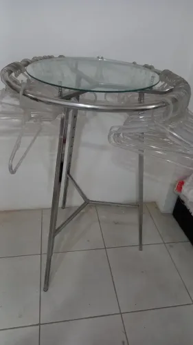  ARARA redonda cromada com tampo de vidro para exposição de roupas.