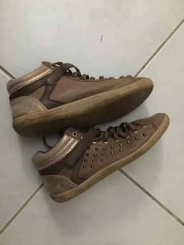 Tênis marrom com detalhes em dourado tipo bota