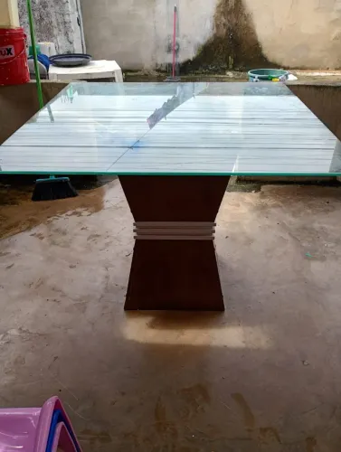 Mesa de vidro com base em madeira