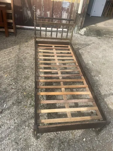 Cama de solteiro de madeira maciça, cor marrom escuro, em bom estado.