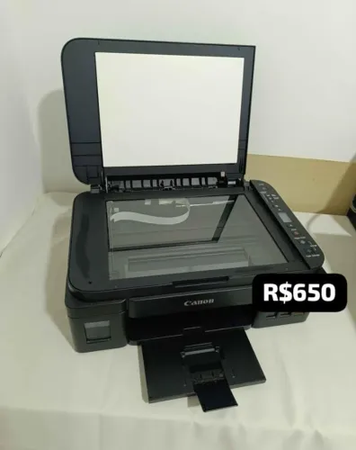 Impressora na caixa e tintas no tanque, vai alguns papéis