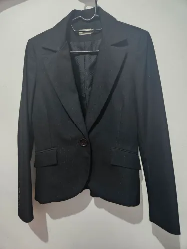Blazer preto com ombreira, detalhes de risca de giz brilhante no tecido
