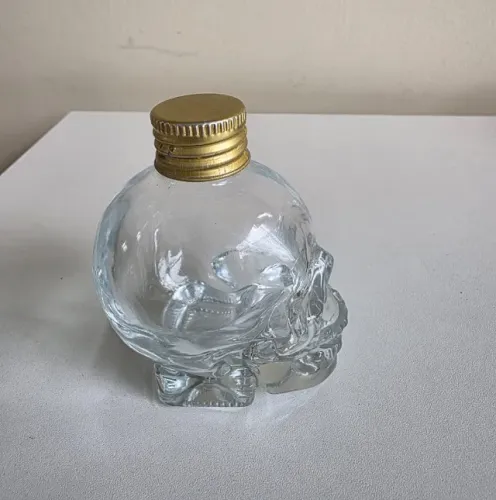 Garrafa de vidro caveira decorativa com tampa metálica
