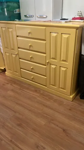 Cômoda laqueada em amarelo com gavetas e cabideiro. 