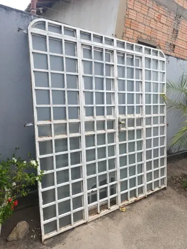 Porta de ferro com vidro, estilo colonial e janelas grandes 