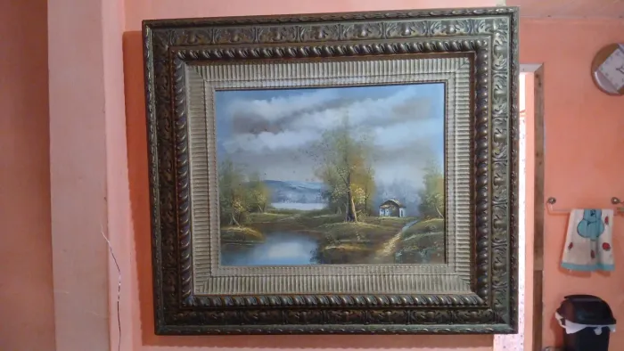 Quadro de paisagem com moldura estilizada.