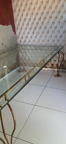 Mesa de jantar com estrutura em ferro forjado e tampo de vidro