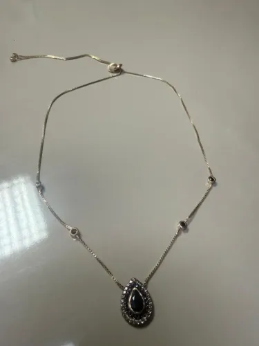 Colar estilo gravatinha com pingente escuro e pedras