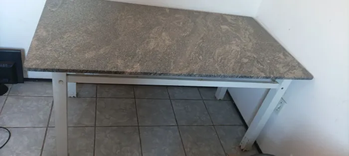 Mesa com tampo de granito e estrutura de metal