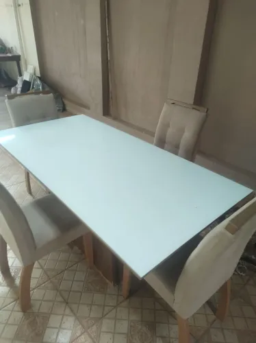 Mesa de jantar moderna com uatro cadeiras estofadas com tecido veludo.