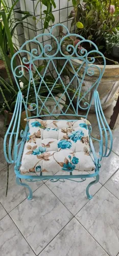Cadeira de ferro azul com almofada floral