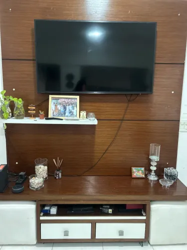 Painel de TV para sala com móvel de rodinhas e puffs
