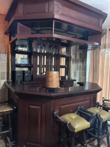 Bar de madeira com cadeiras revestidas em couro