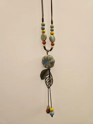 Colar artesanal com pingente floral em cerâmica e metal