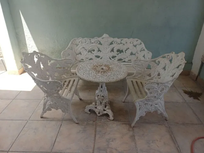 Mesa em ferro fundido com duas cadeiras. 